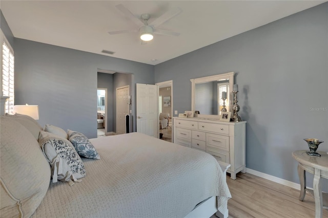 bedroom featuring light wood-type flooring, ceiling fan, and connected bathroom