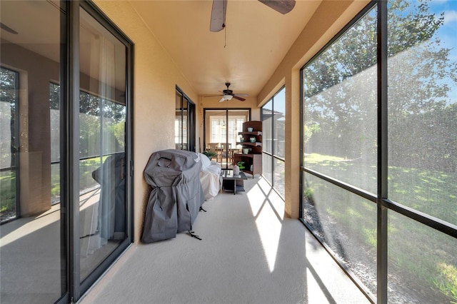 unfurnished sunroom featuring ceiling fan