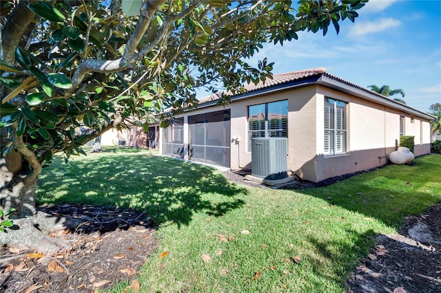 view of home's exterior with a sunroom, central air condition unit, and a lawn