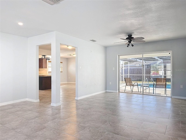 tiled spare room with ceiling fan