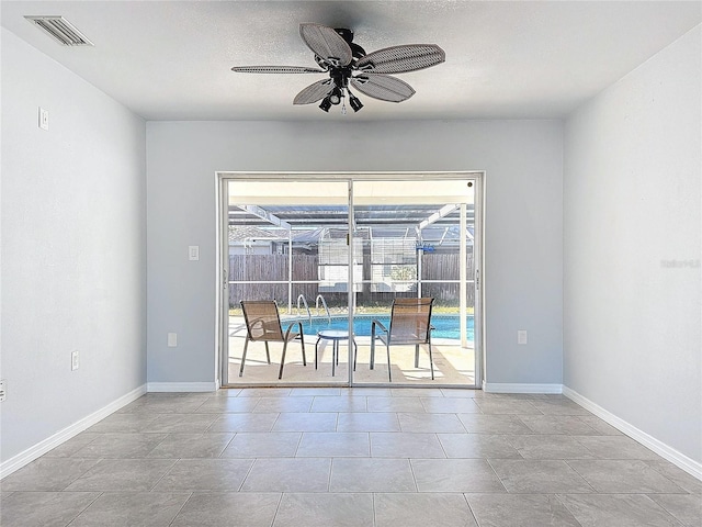 unfurnished dining area featuring light tile patterned floors, a textured ceiling, a wealth of natural light, and ceiling fan