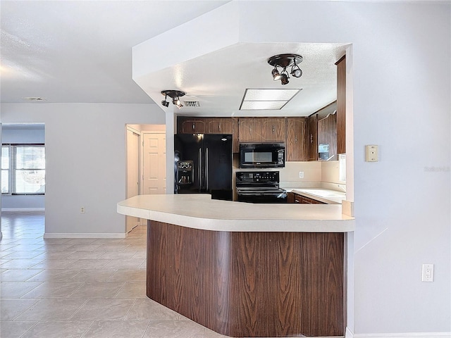 kitchen featuring kitchen peninsula, sink, light tile patterned floors, and black appliances