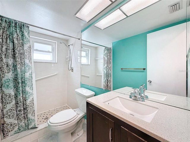 bathroom featuring a shower with shower curtain, vanity, toilet, and tile patterned floors