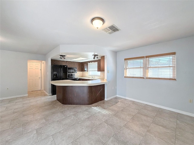 kitchen with kitchen peninsula, light tile patterned flooring, and black appliances