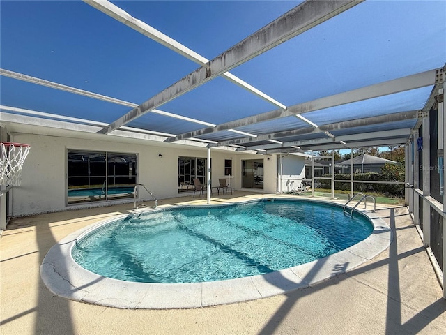 view of swimming pool with a patio area and a lanai