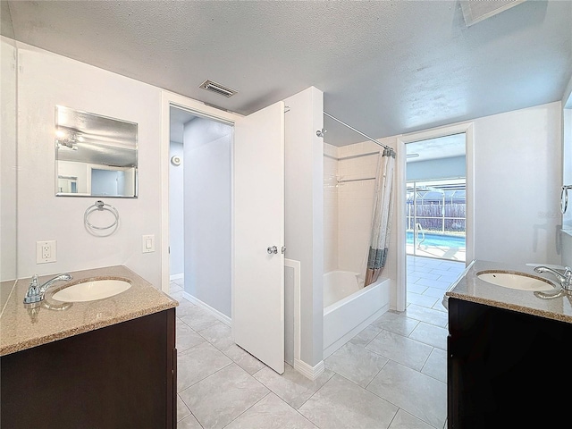 bathroom with tile patterned flooring, vanity, a textured ceiling, and shower / tub combo with curtain