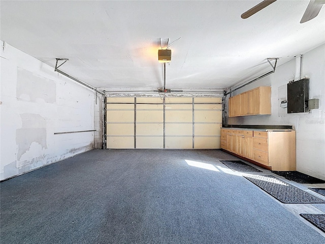 garage featuring ceiling fan, a garage door opener, and electric panel