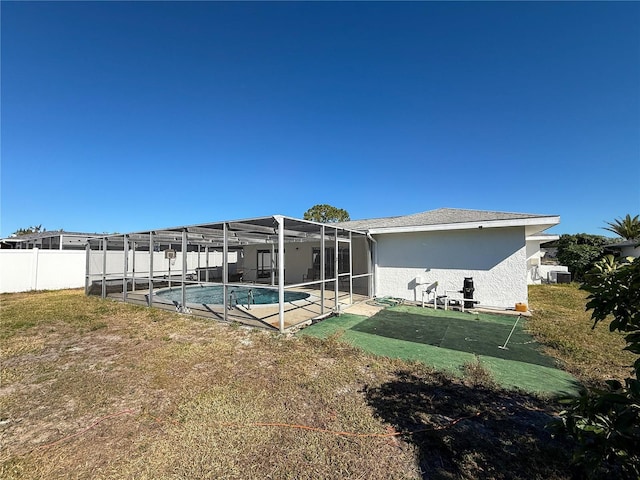 rear view of house with a lanai and a fenced in pool