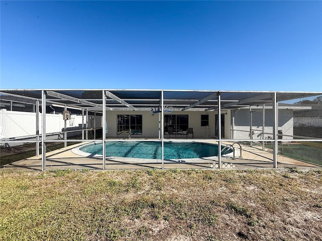 back of property featuring a fenced in pool, glass enclosure, and a patio area