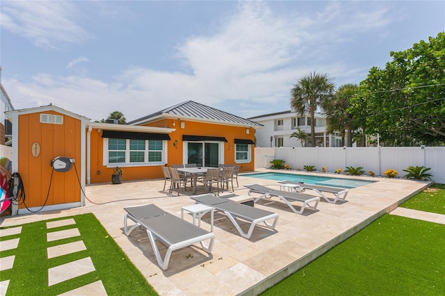 view of swimming pool featuring a patio and a shed