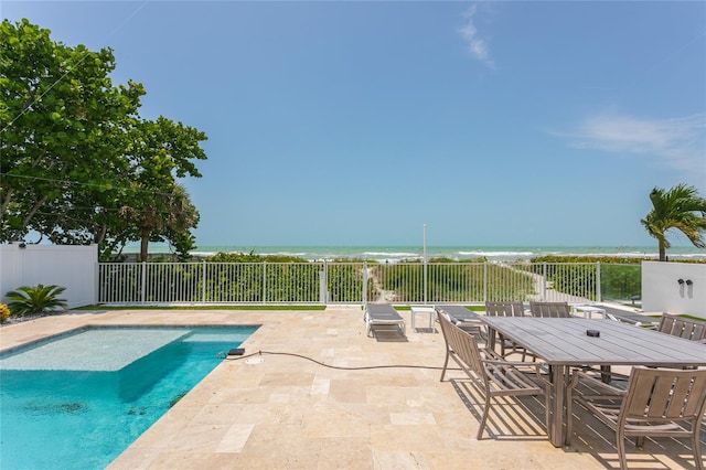 view of swimming pool featuring a water view and a patio