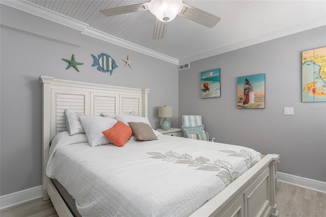 bedroom with ceiling fan, crown molding, and light hardwood / wood-style flooring