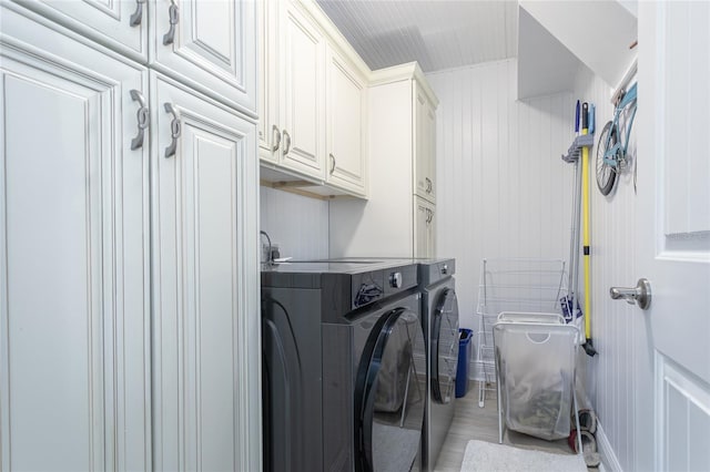 clothes washing area with cabinets and independent washer and dryer