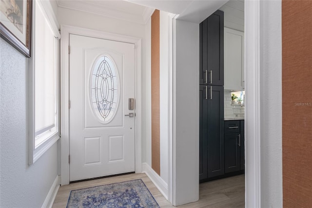 foyer entrance with crown molding and light hardwood / wood-style floors