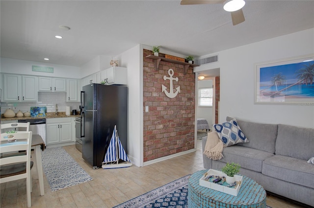 living room with light hardwood / wood-style floors, ceiling fan, and sink