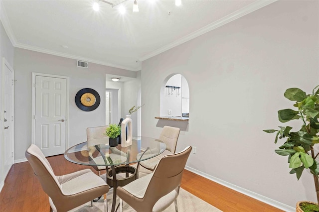 dining room featuring hardwood / wood-style flooring and crown molding