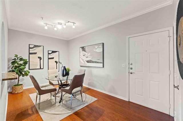 interior space with rail lighting, dark hardwood / wood-style flooring, and crown molding