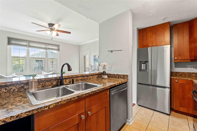 kitchen featuring appliances with stainless steel finishes, ornamental molding, a textured ceiling, sink, and light tile patterned floors