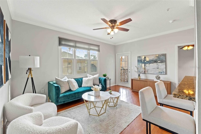 living room featuring light hardwood / wood-style floors, ceiling fan, and ornamental molding