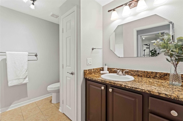 bathroom featuring tile patterned floors, vanity, and toilet