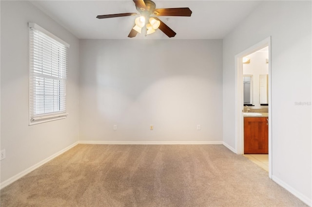 carpeted spare room with ceiling fan and sink