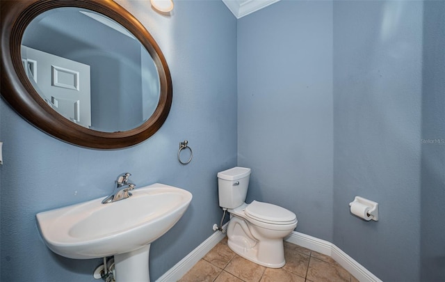 bathroom with tile patterned floors, toilet, ornamental molding, and sink