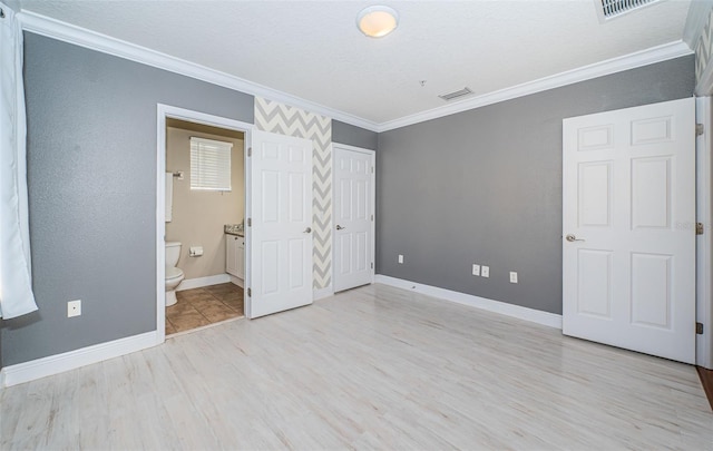 unfurnished bedroom with light wood-type flooring, ensuite bath, and ornamental molding