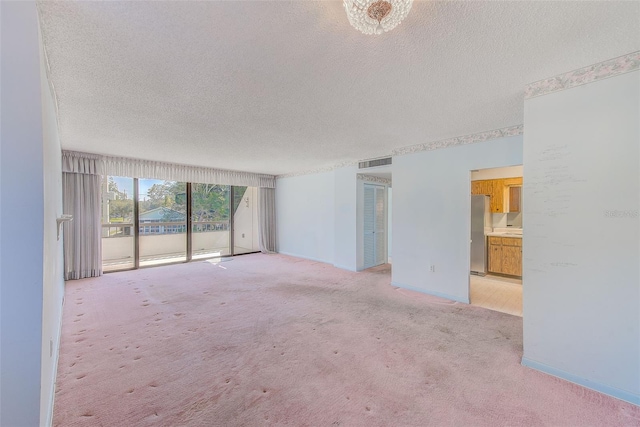 carpeted spare room featuring a textured ceiling