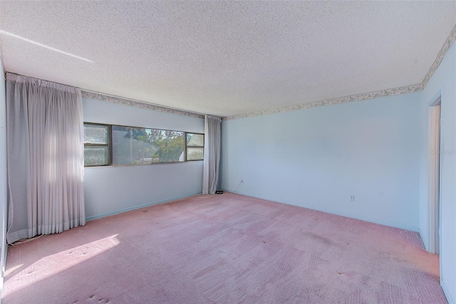 spare room featuring a textured ceiling and light carpet