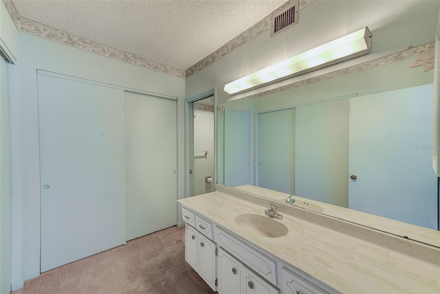 bathroom with a textured ceiling and vanity