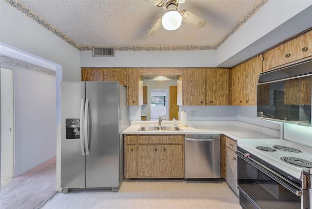 kitchen with ceiling fan, sink, stainless steel appliances, and a textured ceiling