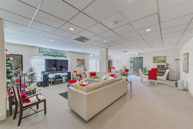 living room featuring a paneled ceiling and a healthy amount of sunlight