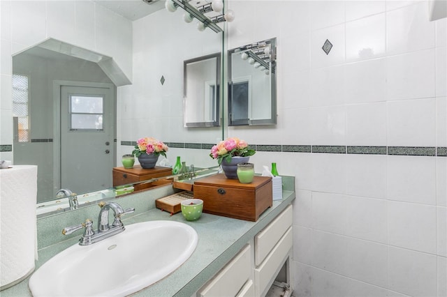 bathroom with vanity and tile walls