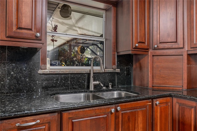 kitchen with decorative backsplash, sink, and dark stone counters