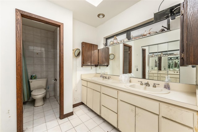 bathroom featuring tile patterned flooring, vanity, and toilet