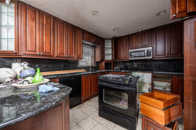 kitchen featuring dark stone counters, a textured ceiling, sink, black appliances, and light tile patterned floors