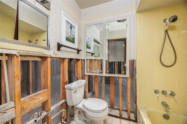 bathroom featuring tiled shower / bath combo and toilet