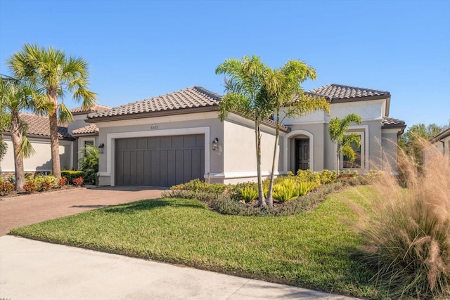 mediterranean / spanish house featuring a garage and a front yard