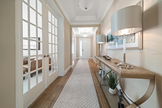 doorway with hardwood / wood-style flooring, french doors, crown molding, and a tray ceiling