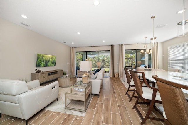 living room featuring a chandelier and light wood-type flooring