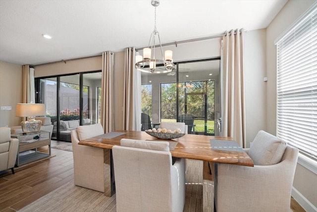 dining room featuring a notable chandelier, light hardwood / wood-style floors, and a healthy amount of sunlight