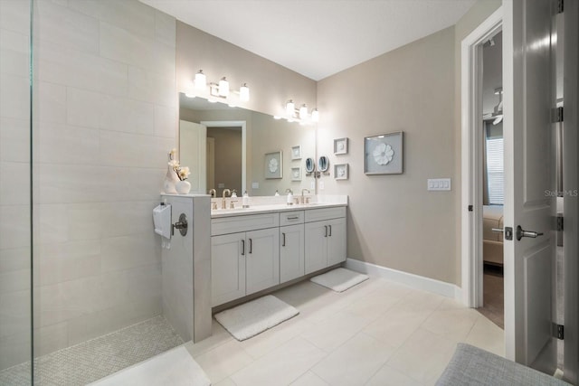 bathroom featuring a tile shower, tile patterned flooring, and vanity