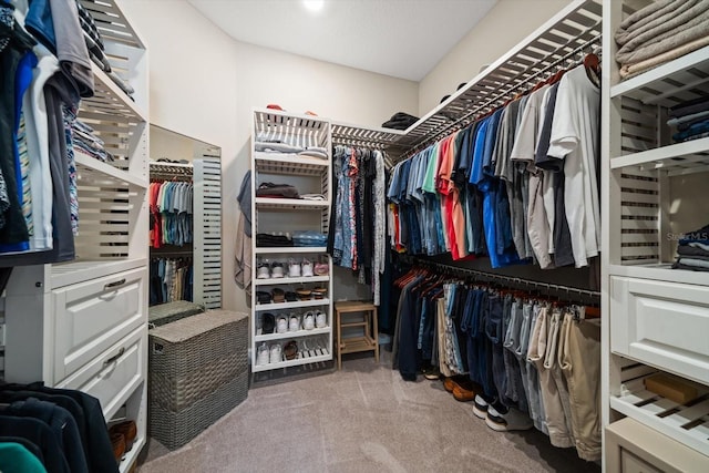 walk in closet featuring light colored carpet