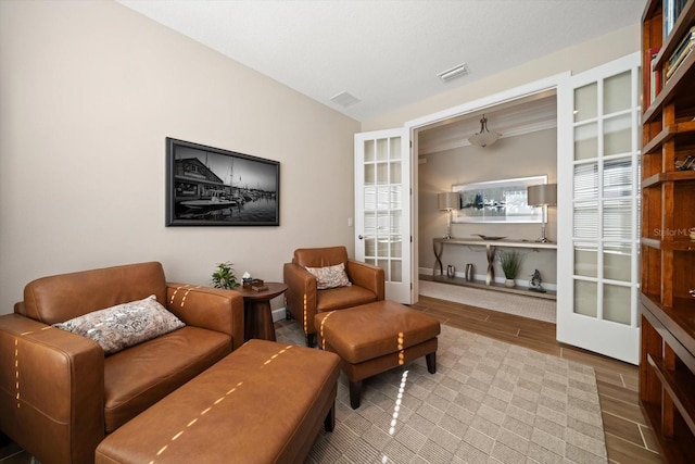 living area featuring hardwood / wood-style floors, vaulted ceiling, and french doors