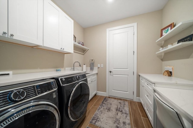 laundry room featuring cabinets, dark hardwood / wood-style flooring, washer and dryer, and sink