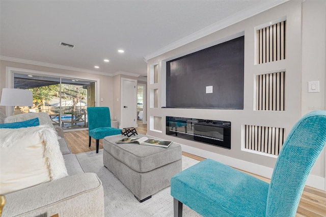 living room with ornamental molding and light hardwood / wood-style floors