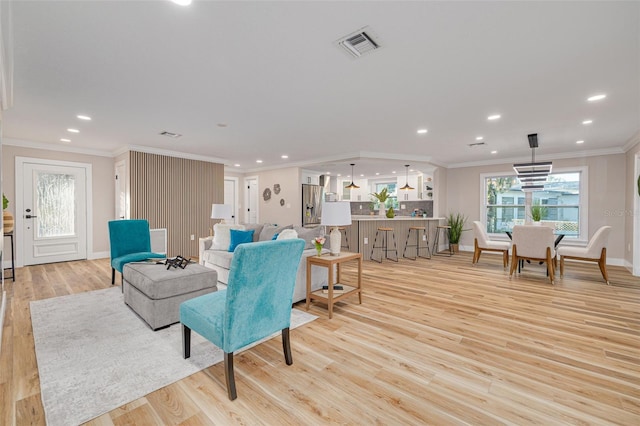 living room with crown molding and light hardwood / wood-style flooring