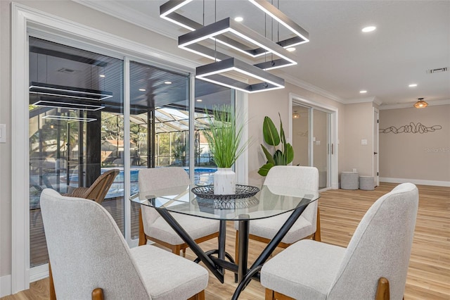 dining area featuring wood-type flooring and ornamental molding