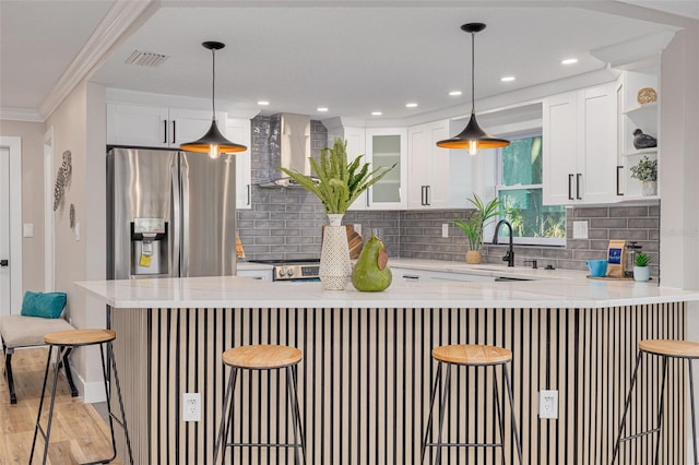 kitchen featuring white cabinetry, a kitchen bar, kitchen peninsula, and stainless steel fridge with ice dispenser