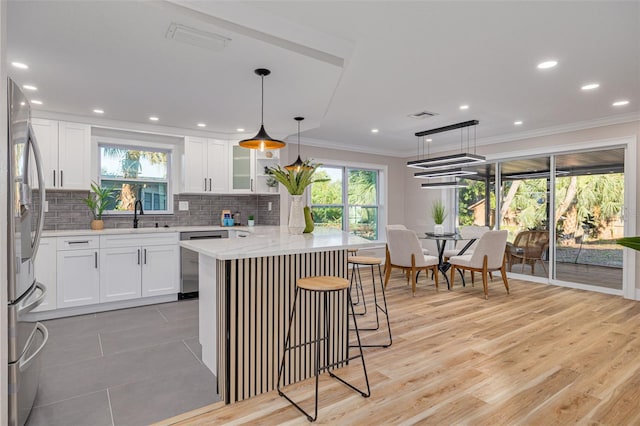 kitchen featuring hanging light fixtures, white cabinetry, and appliances with stainless steel finishes